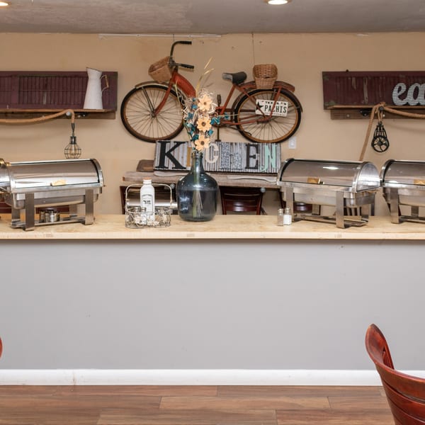 Mama's Bistro Cafe and Bakery's rustic buffet counter with chafing dishes and vintage decor.