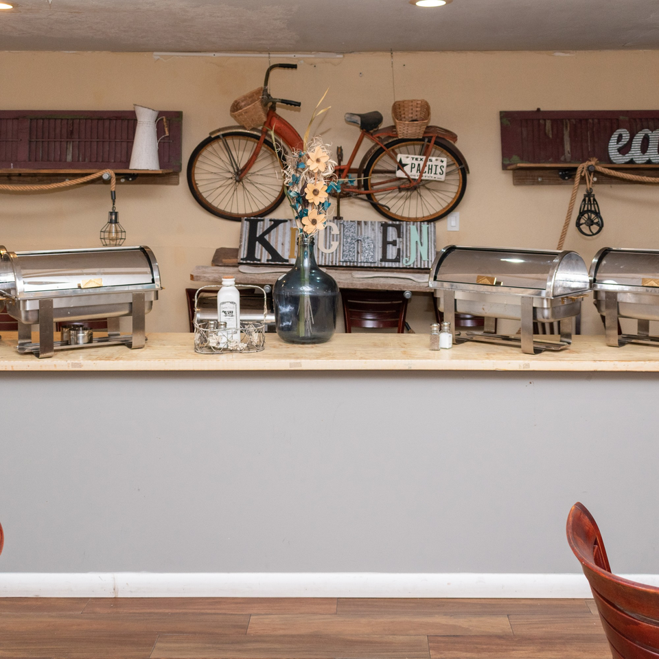 Mama's Bistro Cafe and Bakery's rustic buffet counter with chafing dishes and vintage decor.