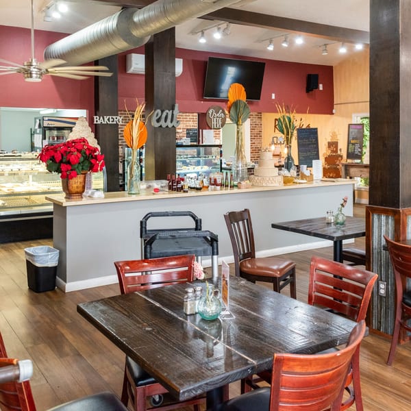 Interior of Mama's Bistro Cafe and Bakery, showing dining tables, bakery counter, and menu boards.